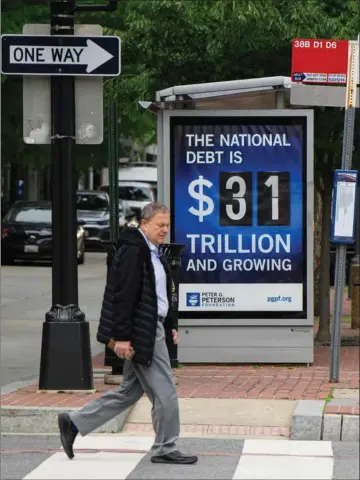  ?? ?? En plakat ved et busstop i Washington viser, hvor stor den enorme amerikansk­e statsgaeld er. Foto: AFP/Ritzau Scanpix
