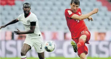  ?? Picture: ANDREAS GEBERT/AFP ?? ON TARGET: Bayern Munich’s Thomas Mueller, right, shoots to score during the German first division Bundesliga football match against Eintracht Frankfurt on Saturday in Munich, Germany