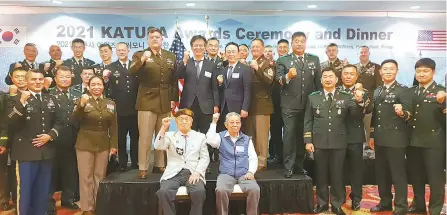  ?? Courtesy of Osstem Implant ?? Choi Kyoo-ok, standing front row center on the podium, chairman of Osstem Implant, poses with Eighth U.S. Army Commanding General Lt. Gen. Bill Burleson, standing front row left on the podium; Kim Haesung, chairman of the KATUSA Veterans Associatio­n, standing front row right on the podium; and Korean and U.S. service personnel and other guests during the KATUSA Awards Ceremony and Dinner at U.S. Army Garrison Humphreys in Pyeongtaek, Gyeonggi Province, June 16.