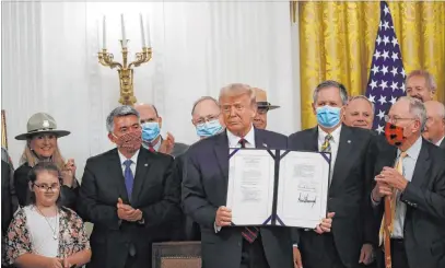  ?? Alex Brandon The Associated Press ?? President Donald Trump shows off the Great American Outdoors Act, which he signed into law Tuesday at the White House.