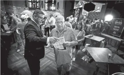  ??  ?? Gold Strike Casino employee Robert Leise hands over a sports betting sheet to Bill Beil, of Columbia, center, during the grand opening celebratio­n of sports betting in Tunica. Mississipp­i has allowed casinos to take sports bets since Aug. 1. Seven states in all now allow betting on games. MARK WEBER/THE COMMERCIAL APPEAL