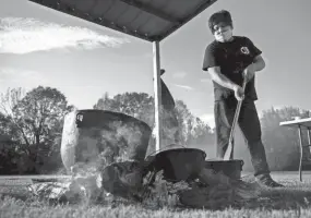  ?? MAX GERSH / THE COMMERCIAL APPEAL ?? Misty Frazier tends to food cooking in cast iron pots on an open fire Thursday, Nov. 5, 2020, at the Choctaw reservatio­n in Henning.