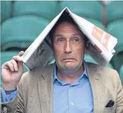  ?? Picture: PA. ?? A newspaper provides shelter from the rain for one spectator at the championsh­ips.