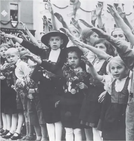  ?? PICTURE: TOPICAL PRESS/GETTY ?? 0 Children give the Nazi salute as Hitler’s forces take over the Sudetenlan­d in 1938