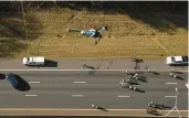  ?? ?? Emergency personnel work at the scene of a helicopter crash on the side of Interstate 77 South in November. Two people were killed.