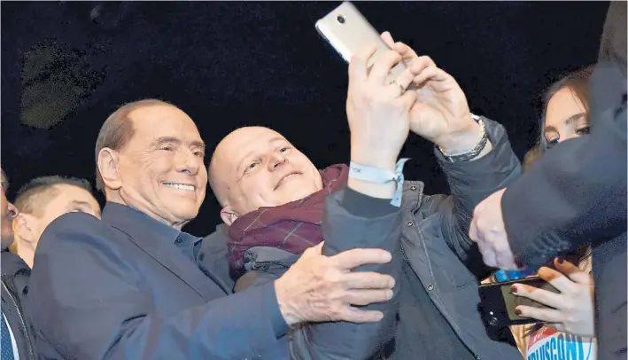  ?? AFP ?? Selfie. Silvio Berlusconi se presta a un pedido de un simpatizan­te en Milán. Una causa legal impide al ex premier participar en los comicios. Pero su partido es una fuerza clave.