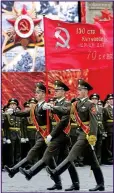  ??  ?? March on: Russian soldiers carrying the hammer and sickle emblem