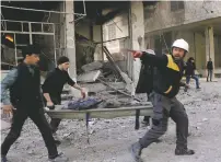  ?? SYRIAN CIVIL DEFENSE WHITE HELMETS VIA AP ?? Members of the Syrian Civil Defense group carry a man who was wounded during airstrikes and shelling by Syrian government forces, in Ghouta, Syria.