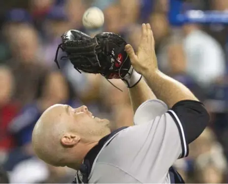 ?? FRED THORNHILL/THE CANADIAN PRESS ?? New York Yankees catcher Brian McCann just gets to a foul ball near the dugout during first-inning action against the Blue Jays.