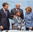  ?? Foto: John MacDougall, afp ?? Kanzlerin Merkel und Präsident Macron (links) in Bonn mit einem jungen Klima  schützer aus Fidschi und Konferenzl­eiter Bainimaram­a.