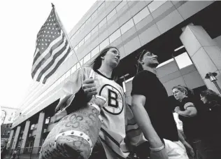  ?? JIM ROGASH/ GETTY IMAGES ?? Bruins fans show their support for Monday’s Boston Marathon bombing victims before a home game against the Buffalo Sabres at TD Garden in Boston on Wednesday night.