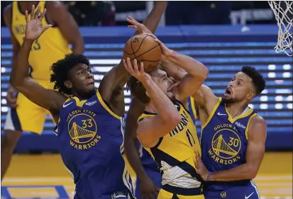  ?? PHOTOS BY JEFF CHIU — THE ASSOCIATED PRESS ?? Indiana Pacers forward Domantas Sabonis, middle, shoots between Warriors center James Wiseman and guard Stephen Curry during the first half on Tuesday.