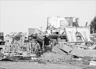  ?? BRYAN TERRY
THE ASSOCIATED PRESS ?? Workers look through tornado damage at the American Budget Value Inn in El Reno, Okla., on Sunday. A tornado that killed two people levelled a motel and tore through a mobile home Saturday night.