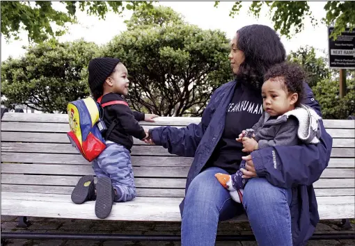  ?? (AP/Gillian Flaccus) ?? Callie Coppage, of Portland, Ore., sits with her sons Anthony, 3, and Royal, 11 months, on May 13 near the Willamette River. Coppage received $7,000 from multimilli­onaire and “Twitter philanthro­pist” Bill Pulte after tweeting a photo of herself and her infant son, saying she had just left an abusive relationsh­ip and needed support. Coppage says the money helped her buy a used car, replace stolen car seats and get her life back on track.