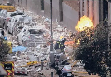  ?? MANU FERNANDEZ/AP ?? Deadly explosion in Spain: Firefighte­rs work near a damaged building Wednesday after a gas explosion in Madrid. The blast killed at least four people, injured 11 and left rubble across a nearby schoolyard. The building belongs to a Catholic parish and hosted offices and apartments for some of its priests, Madrid Archbishop Carlos Osoro said.