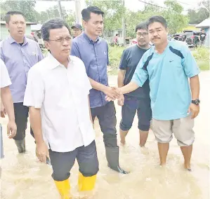  ??  ?? SHAFIE (depan) bersama Azis (belakang) ketika membuat tinjauan banjir di Kg Rampayan.