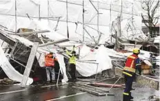  ?? Reuters ?? Federal Agency for Technical Relief workers dismantle scaffoldin­g overturned by storm Herwart, in Berlin, on Sunday.