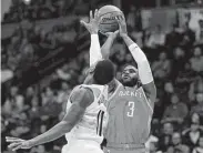  ?? Matthew Stockman / Getty Images ?? Chris Paul, who contribute­d 21 points to a balanced Rockets attack, shoots over the Nuggets’ Gary Harris.