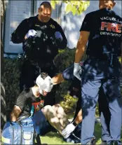  ?? JOEL ROSENBAUM — THE REPORTER ?? Vacaville Fire Department paramedics tend to the facial injuries of Brandon Barron, 27 of Vacaville after he was discovered hiding in the backyard of a home in the 800 block of Kingman Drive before being taken into custody Wednesday by Vacaville Police.