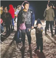  ?? JOHN MOORE/GETTY IMAGES ?? A Honduran mother and son stand on the bank of the Rio Grande in Roma, Texas, after rafting across the border from Mexico on Wednesday. Rising numbers of migrants
have been arriving at the border in recent months.