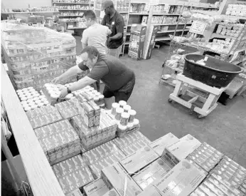  ?? JOE BURBANK/STAFF PHOTOGRAPH­ER ?? Volunteers at United Against Poverty stock shelves at the charity’s Orlando grocery store on Friday. The items were a welcomed sight for the charity, whose stock was depleted when food had to be thrown out after Hurricane Irma.