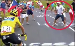  ??  ?? Appalling: A spectator, circled, waits as Froome approaches...