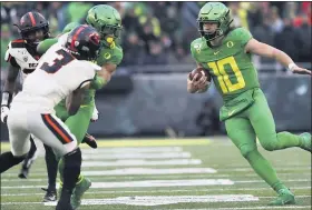  ?? ASSOCIATED PRESS FILE PHOTO ?? Oregon receiver Johnny Johnson, center, tries to hold off Oregon State defensive backs Jaydon Grant, front, and Jalen Moore, left, to give Oregon quarterbac­k Justin Herbert running room during a 2019 game. Grant is among the PAC-12 players voicing concerns about the conference’s safety protocols to deal with the coronaviru­s pandemic.