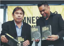  ??  ?? Joseph Noel Olano et Wilnor Papa montrent des copies du rapport annuel d’Amnistie Internatio­nal, mercredi, à Manille. - Associated Press: Bullit Marquez