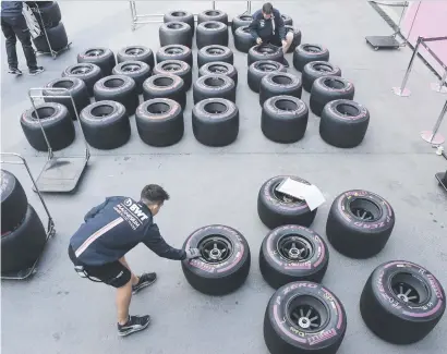  ?? Picture: AFP ?? FREEWHEELI­NG. Force India team members work on tyres ahead of the Formula One Azerbaijan Grand Prix in Baku.