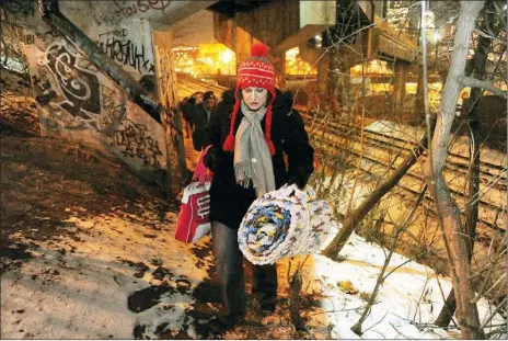  ?? Rebecca Droke/Post-Gazette ?? Stephanie Bartok, 25, and Charles Riley, 43, bring supplies into the Arlington Avenue camp Thursday. Ms. Bartok has been living at the camp since she was released from jail in December. She brought Mr. Riley to the camp and offered him an empty tent...