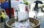  ?? EUGENE HOSHIKO — THE ASSOCIATED PRESS ?? A block of ice is placed at a pedestrian street to cool down the spot in Tokyo Friday. A deadly heat wave in Japan has many residents in the Japanese capital questionin­g the wisdom of staging the Tokyo 2020 Olympics in July and August.