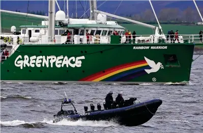  ?? ?? Stormy waters: Police escort Greenpeace vessel Rainbow Warrior as it heads up the Clyde