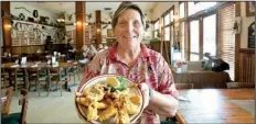  ??  ?? AP Fran Adams displays a plate of fried frog legs at her cafe, Marsh Landing, in Fellsmere, Fla.