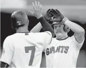  ?? BEN MARGOT/ASSOCIATED PRESS ?? The Giants’ Nick Hundley, right, celebrates with Aaron Hill (7) after hitting a two-run homer against the Braves.