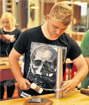  ?? PHOTO: CONTRIBUTE­D ?? TRUE CREATIVITY: Mitchell Hill creates a stamped aluminium cuff in a jewellery making workshop for teenagers at Cobb+Co Museum.