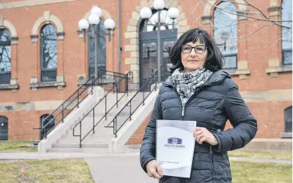  ?? STU NEATBY/THE GUARDIAN ?? Auditor general Jane MacAdam holds a copy of her final report. The 2020 report, released in mid-March, includes an audit of the AccessAbil­ity Services Program, IT security practices in government and Health P.E.I.'s laboratory services.