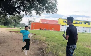  ?? Photograph­s by Kate Linthicum Los Angeles Times ?? WILMER MAURICIO LOPEZ, 19, right, and his friend Christian Rauldales, 24, play soccer outside a shelter in Tenosique, Mexico, while waiting for “La Bestia,” the train they will try to ride north to the United States.