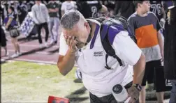  ??  ?? A Basic football staffer flushes his eyes after being pepper-sprayed by a police officer after a brawl between the Canyon Springs and Basic high school football teams at the end of a game Friday at Basic High School in Henderson.