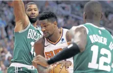  ?? ASSOCIATED PRESS ?? IN TRAFFIC: Celts Marcus Morris (left) and Terry Rozier try to contain Phoenix’ Deandre Ayton last week.