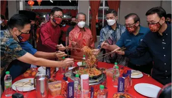  ?? — Bernama photo ?? Muhyiddin (centre) tossing ‘Yee Sang’ at the Perikatan Nasional (PN) Chinese New Year reception on Thursday night.