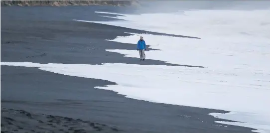  ?? PHOTOS: FRANK AUGSTEIN/THE ASSOCIATED PRESS ?? A man walks on the black sanded beach in Vik, Iceland, near the Volcano Katla. The landscape has a stark beauty.