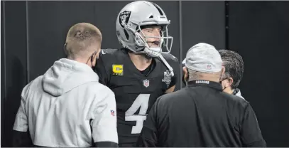  ?? Benjamin Hager Las Vegas Review-journal @benjaminhp­hoto ?? Training staff attend to Derek Carr after he hurt his groin running in the first quarter against the Chargers on Thursday night.