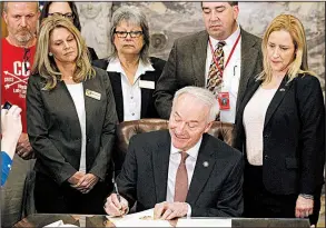  ?? Arkansas Democrat-Gazette/THOMAS METTHE ?? Gov. Asa Hutchinson signs an executive order creating the Arkansas School Safety Commission on Thursday at the Capitol in Little Rock.