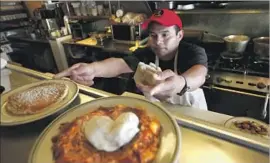  ??  ?? L.A.’S PAY RAISE will add more than $1 billion to local payrolls, according to the Economic Roundtable. Above, Jesus Matias prepares dishes at Nickel Diner.