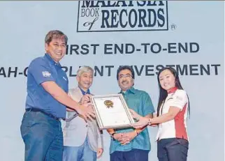  ?? PIC BY HAFIZ SOHAIMI ?? Second Finance Minister Datuk Seri Johari Abdul Ghani (second from right) and Bursa Malaysia chairman Tan Sri Amirsham Abdul Aziz (second from left) looking on as Bursa Malaysia chief executive officer Datuk Seri Tajuddin Atan (left) receives a...