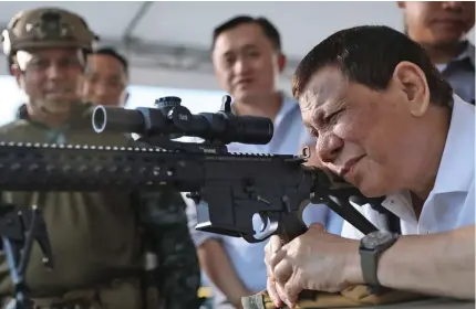  ?? Photo: AFP ?? President Rodrigo Duterte fires a few rounds with a sniper rifle during the opening ceremony of the National Special Weapons and Tactics Challenge in Davao City, southern Philippine in November last year.