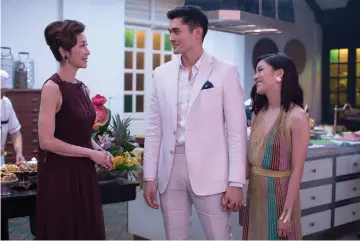  ??  ?? (From left) Tan Sri Michelle Yeoh, Henry Golding and Constance Wu star in ‘Crazy Rich Asians.’ — Photo by Sanja Bucko, Warner Bros. Pictures