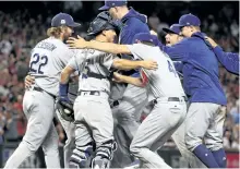  ?? CHRISTIAN PETERSEN/GETTY IMAGES ?? Los Angeles Dodgers’ pitcher Clayton Kershaw celebrates with teammates after defeating the Arizona Diamondbac­ks 3-1 to win the National League Divisional Series at Chase Field, on Monday, in Phoenix, Ariz.