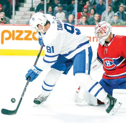  ?? JOHN MAHONEY ?? Toronto centre John Tavares deflects a shot in front of goaltender Carey Price during preseason action at the Bell Centre last September. Toronto and Montreal have only met once this regular season, when the Leafs beat the Canadiens 3-2 in overtime on opening night in Toronto.