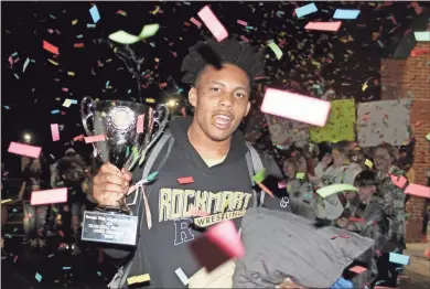  ?? Jeremy Stewart ?? Rockmart’s Hunter Wilson is showered by confetti while holding the Class AA state duals championsh­ip trophy after getting off of the wrestling team’s bus at Rockmart High School late Saturday night. Fans met the team as they returned from the state finals in Hazlehurst.